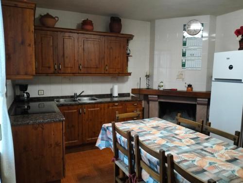 eine Küche mit einem Tisch und einem weißen Kühlschrank in der Unterkunft Casa Rural Mikelenea in Lecároz
