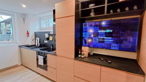 a kitchen with a large flat screen tv on a wall at alte Bäckerei Ottendorf-Okrilla #Fritz# in Ottendorf-Okrilla