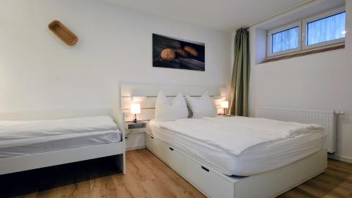 two beds in a white room with two windows at alte Bäckerei Ottendorf-Okrilla #Fritz# in Ottendorf-Okrilla