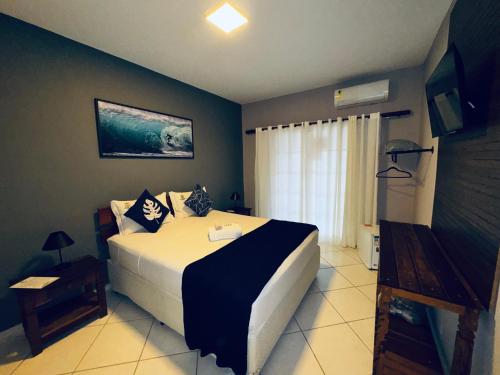 a bedroom with a large bed and a window at Pousada Vista Dell Mar in Ubatuba