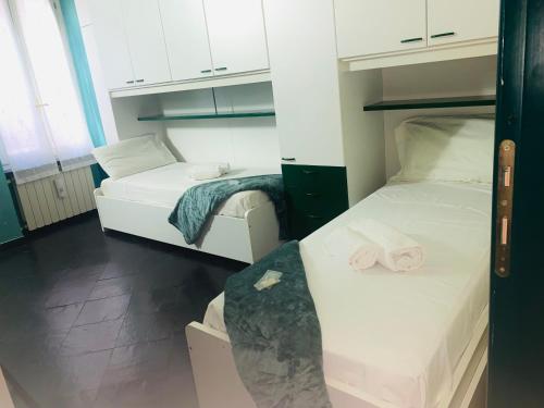 a small room with two beds and a sink at Mediterranium in Loano