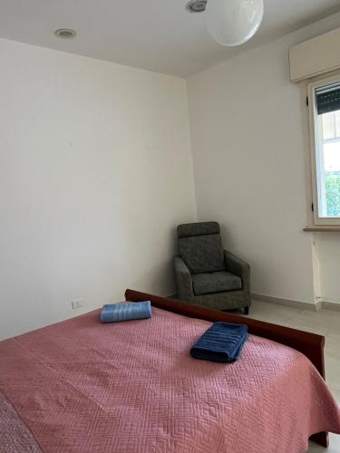a bedroom with a large bed and a chair at bilocale mirabilandia in Borgo Fosso Ghiaia