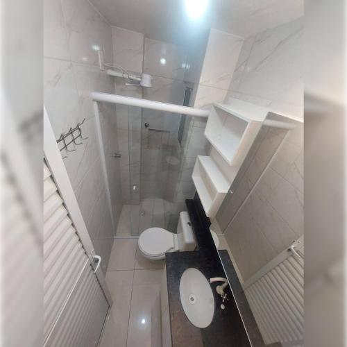 a white bathroom with a toilet and a shower at Hotel Tejas Verdes in Villa Gesell