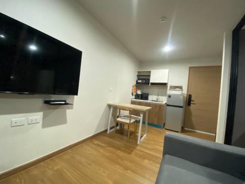 Ban Pra DokにあるCaesar's Suite Condo Koratのリビングルーム(壁に大画面薄型テレビ付)