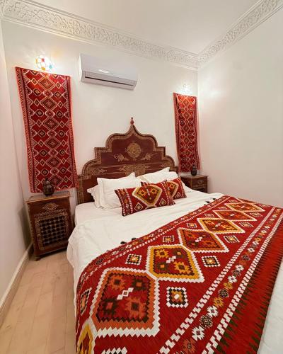 a bedroom with a bed with a red and gold blanket at Dar Skouri 51 in Marrakesh