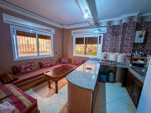 a kitchen with a table and a couch in a room at Étoile de la mer in Ksar es Sghir