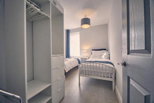 a small bedroom with a bed and a closet at Roselyn By The Sea - Pet Friendly Accommodation in Newbiggin-by-the-Sea
