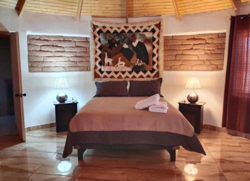 a bedroom with a bed with a headboard and two lamps at Desayuno Habitación TourLodge in San Pedro de Atacama
