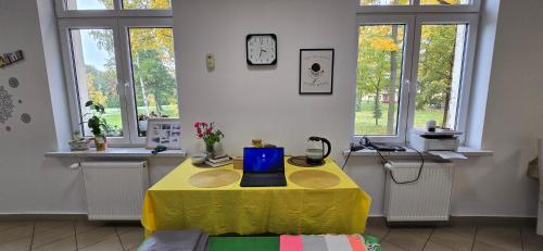 イェレニャ・グラにあるSTREFA ZEN Klimatyczny Pokoj przy Parkuの窓付きの部屋で、ノートパソコン付きのテーブルが備わります。