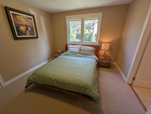 a small bedroom with a bed and a window at Red Brickhouse Lakefront Cottage in Brechin