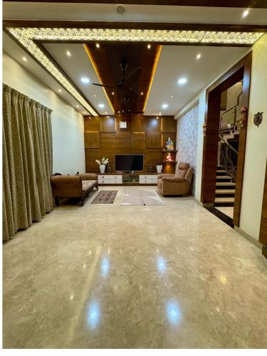 a large living room with a couch and a television at Ultra Luxurious 4 BHK VILLA in Bengaluru