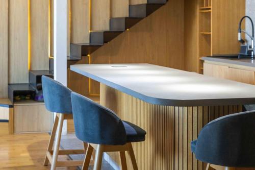 a kitchen with two blue chairs and a counter at Modern Duplex Loft in Skopje City Center with 3 Bedrooms in Skopje