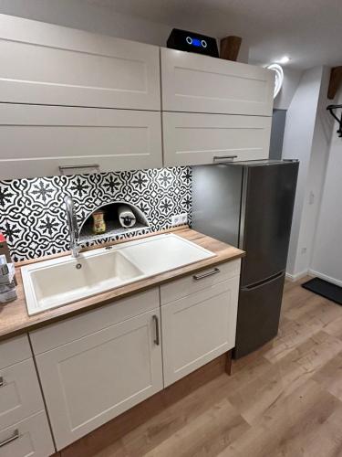 a kitchen with a sink and a refrigerator at Ferienwohnung Südtondern in Uphusum