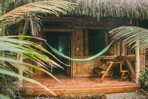 una cabaña de madera con una hamaca frente a ella en Hostal Rosa Mística, en Montañita
