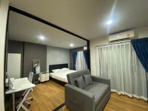 a bedroom with a bed and a desk and a chair at Caesar's Suite Condo Korat - Pool Renovation in Ban Pra Dok