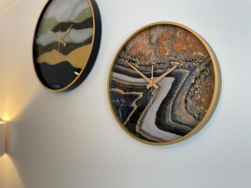 two clocks are hanging on a wall at Cosy Apartment in Beverley in Beverley