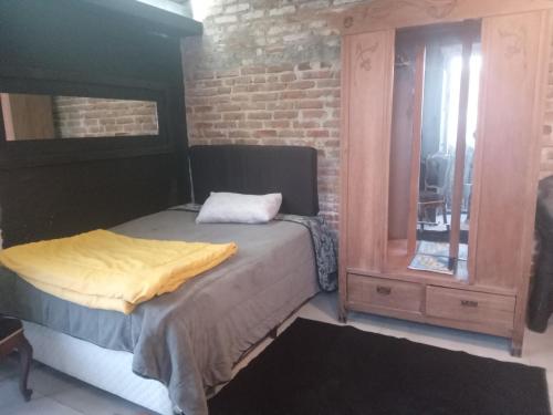 ペロタスにあるLoft central llのベッドルーム1室(ベッド1台、木製ドレッサー付)