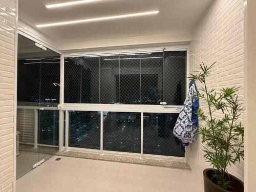 a room with a large window with a plant at Comfort Jardins II - Em frente ao Shopping- Neo Residence in Aracaju