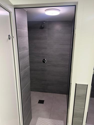 una ducha con puerta de cristal en un baño en Hostel Centrum Katowice, en Katowice