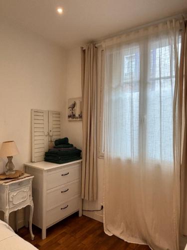 1 dormitorio con ventana, vestidor y cama en Appart à deux pas de paris expo, en Vanves