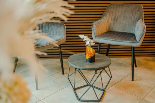 Dos sillas y una mesa con un jarrón. en City Hotel Mercator, en Frankfurt