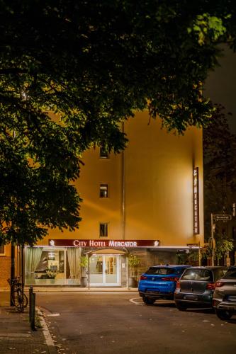 a large yellow building with cars parked in front of it at City Hotel Mercator in Frankfurt