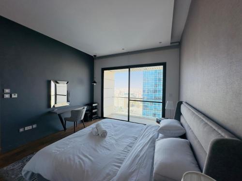 アンマンにあるAmazing Apartment heart of Ammanの大きなベッドと大きな窓のある寝室