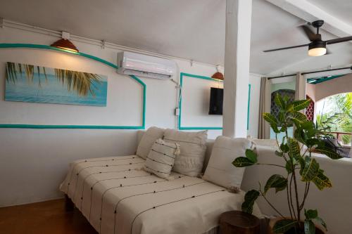 sala de estar con sofá blanco y planta en Sayulita Central Hotel, en Sayulita