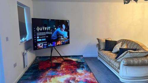a living room with a couch and a flat screen tv at Fabulous 3 bed house close to Lakeside shopping Centre in West Thurrock