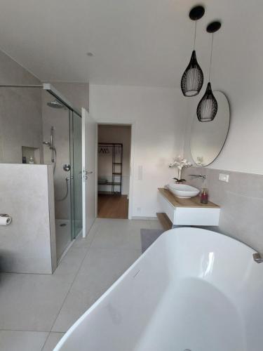 a white bathroom with a tub and a sink at Ferienwohnung Senfnest in Ober-Ramstadt