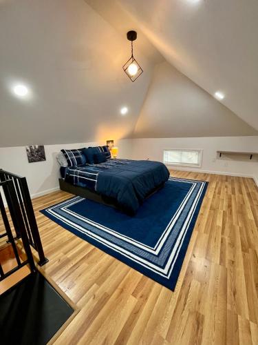 a bedroom with a bed on a blue rug at NYC-Style Loft with Secret Entrance - Just 6 Miles from Times Square in North Bergen