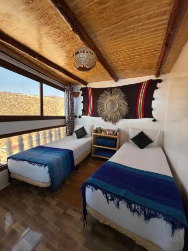 a bedroom with two beds and a window at Ami D'or Hostel in Taghazout