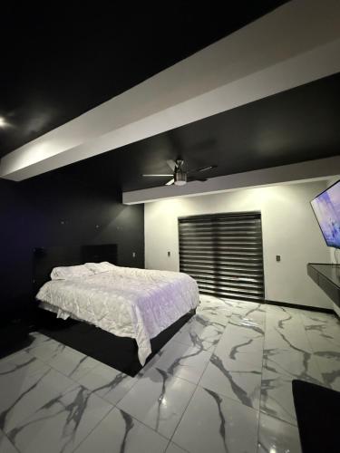 a bedroom with a bed and a flat screen tv at Tu casa en Rosarito en Familia in Rosarito Beach