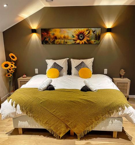 a bedroom with a large bed with yellow pillows at B&B Le Relais de Lou in Jandrenouille