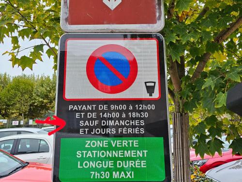 ein Schild auf einem Parkplatz mit geparkten Autos in der Unterkunft Duplex N1 centre-ville, 8 min de la gare de Montluçon in Montluçon