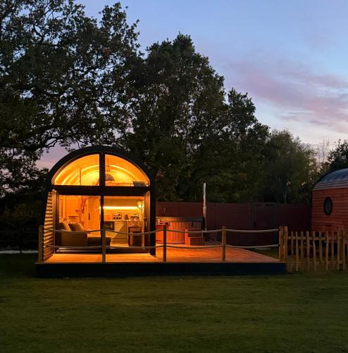 a glass house with a large window in a yard at Luxury Tiny Home next to Belfry Golf Course Highland Cow