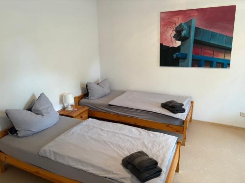 zwei Betten in einem Zimmer mit einem Gemälde an der Wand in der Unterkunft Ferienwohnung Seeglück - 4 Schlaf- & 4 Badezimmer in Tauche