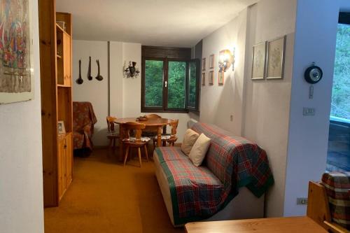 a living room with a table and a couch at Appartamento Magico Abete in Bellamonte