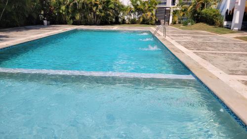 a pool of blue water in a yard at Beautiful apartment near STGO airport in Santiago de los Caballeros