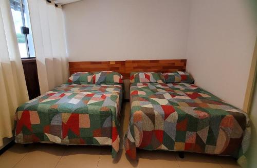 deux lits côte à côte dans une pièce dans l'établissement Pousada Ilha Sul, à Cananéia