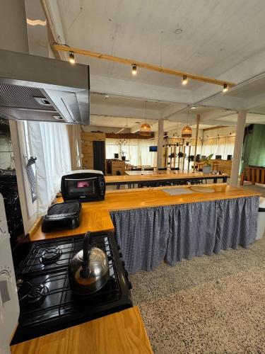 una cucina con un bancone con una stufaasteryasteryasteryasteryasteryasteryasteryasteryastery di Hostel 360 Patagonia a El Bolsón