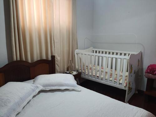 a baby crib in a bedroom with a crib at Aunt A CASA DOS SONHOS DA TIA LETÍCIA in Miguel Pereira