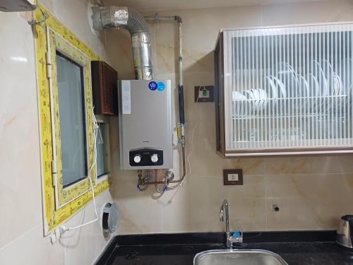 La salle de bains est pourvue d'un lavabo, d'une fenêtre et d'un miroir. dans l'établissement الفريده شقة فندقية, à Mudīrīyah