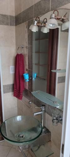 a bathroom with a glass sink and a mirror at Rentals Temp - Deptos in San Clemente del Tuyú