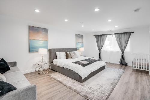 a white bedroom with a bed and a couch at Vacation House with Pool in Garnsey