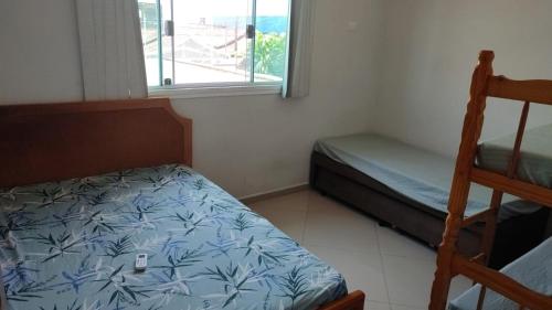 Un dormitorio con una cama y una litera y una ventana. en Casas para Temporada RS, en Praia Grande