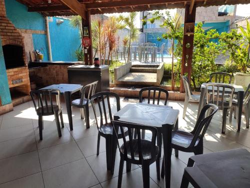 Un restaurante con mesas y sillas en un patio. en Casas para Temporada RS, en Praia Grande