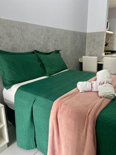 a bedroom with a green bed with green sheets at Studio Pandora in Capim Macio in Natal