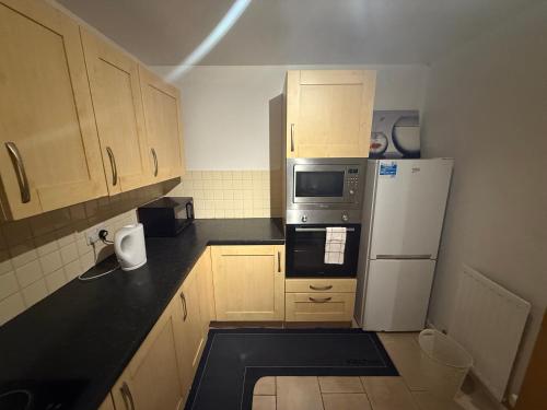 a kitchen with wooden cabinets and a white refrigerator at Spacious Luxury Homes in Elswick