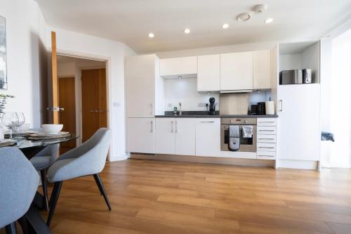 a kitchen with white cabinets and a table and chairs at 1BR River Retreat - Sleeps 4 - Parking in Hoo
